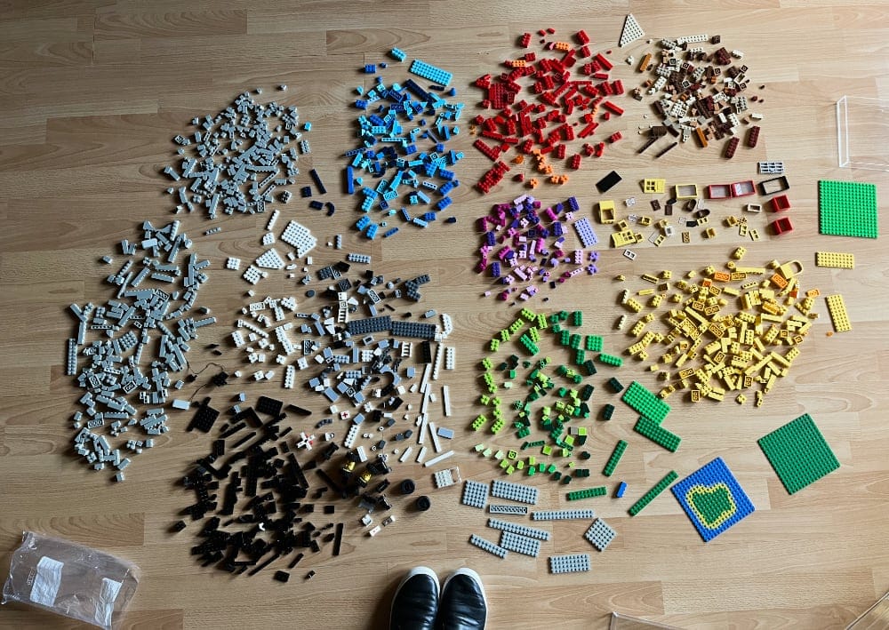 A photo showing my LEGO pieces carefully spread out on the floor, assorted by color